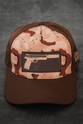 The Choco Chip Silencer Hydro Snapback Hat by Tango Charlie Apparel features a pistol with a silencer patch, brown brim, and perforated side panels for subtle style and functional detail.