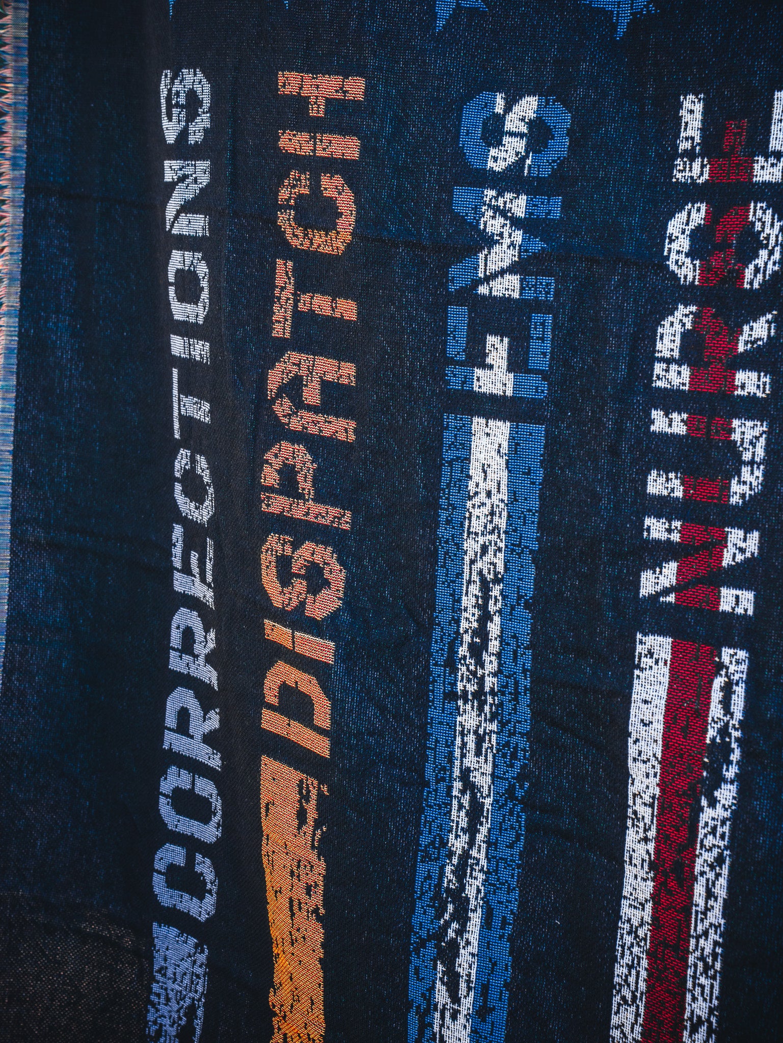 The American Heroes Jacquard Blanket by Born United Private Label features woven vertical stripes and the words CORRECTIONS (blue), DISPATCH (orange), EMS (blue), and NURSE (red) to honor emergency services.