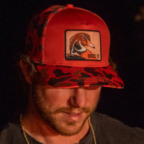 mucker bucket - duck patch orange camo trucker hat on model