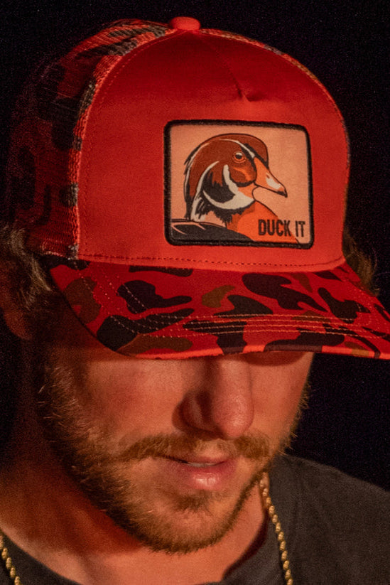 mucker bucket - duck patch orange camo trucker hat on model