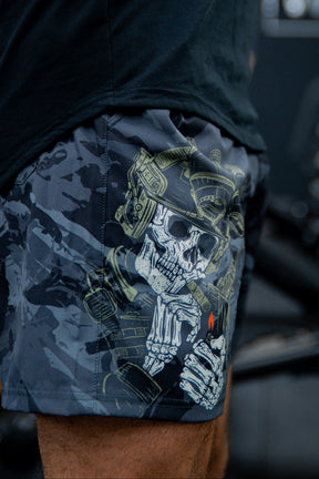 A close-up of a person wearing Born United Private Label Mens Performance Hybrid Shorts 5.5 | Savage Ops, which feature a detailed graphic of a skeleton soldier in a helmet lighting a cigarette with a visible red flame.