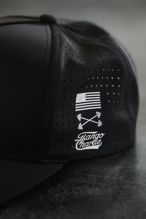 The No One Is Coming To Save You Hydro - Snapback Hat by Tango Charlie Apparel is a black, breathable cap with tiny ventilation holes, featuring a small white American flag and crossed barbells graphic, plus Bando Charlie text on the side.