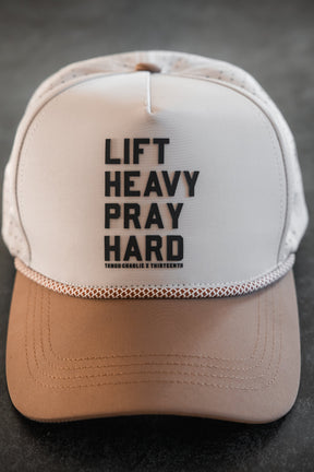 The Tango Charlie Apparel Lift Heavy. Pray Hard. Hydro Snapback Hat, in beige and brown with bold black lettering, is your ideal workout and everyday accessory.
