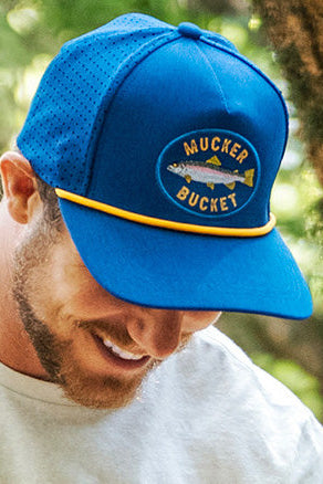 mucker bucket - rainbow trout blue bucket on model closeup