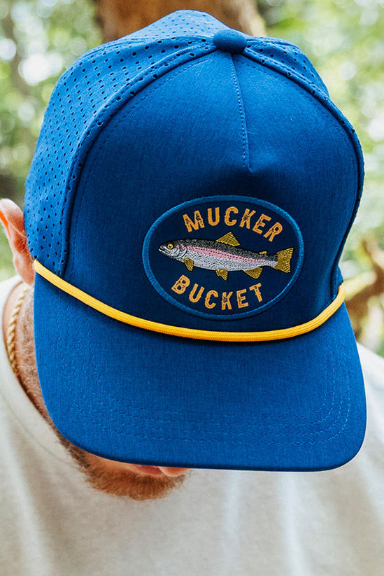 mucker bucket - rainbow trout blue bucket on model front