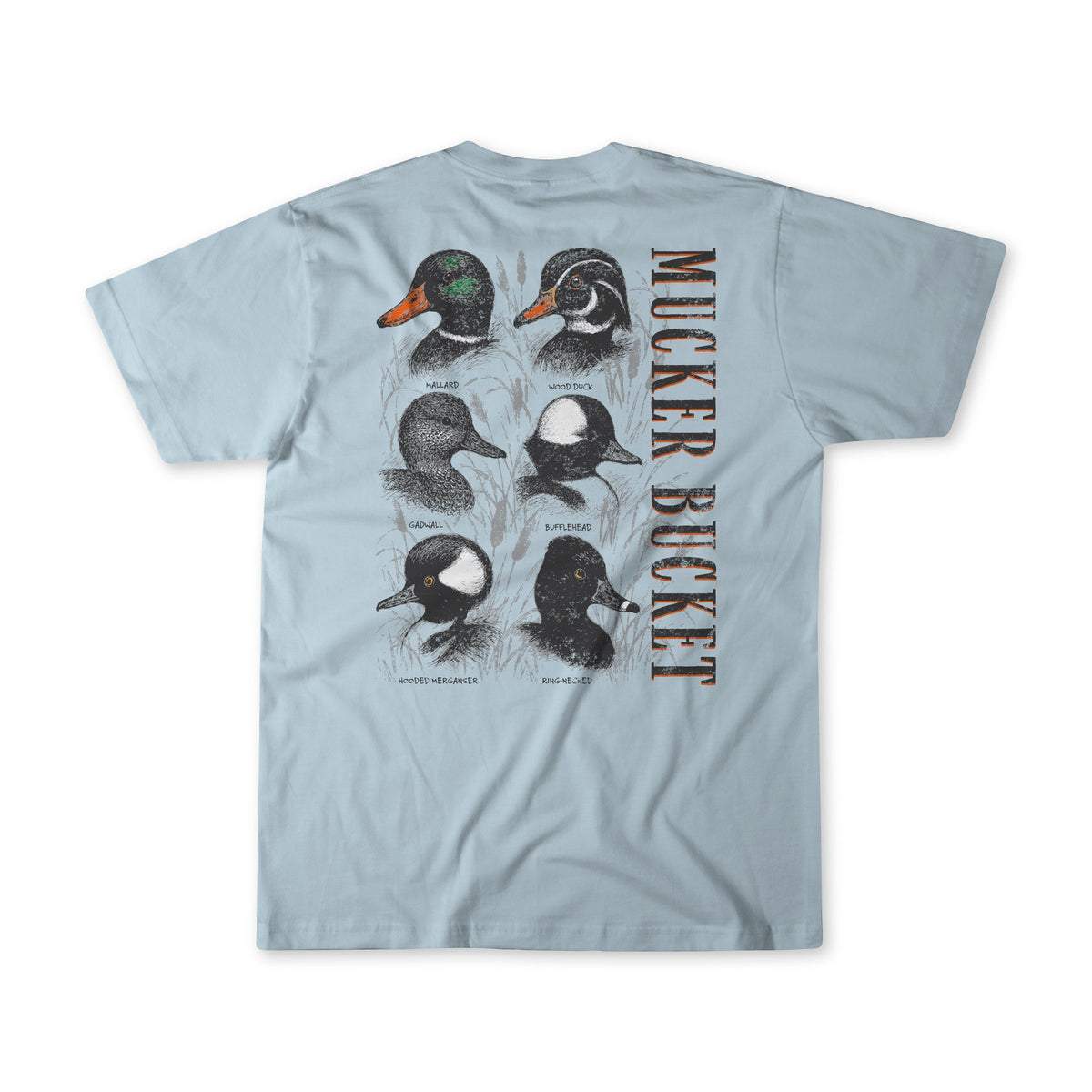 The Mucker Bucket Duck DNA Premium Tee is a light blue, garment-dyed, relaxed fit shirt featuring six illustrated duck species heads and bold "MUCKER BUCKET" text on the back.