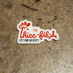 The Thicc-Fil-A Patch from Tango Charlie Apparel is a 3-inch patch featuring red script, a paw print design, and the phrase "Lift mor weights" in smaller text, perfect for textured surfaces.