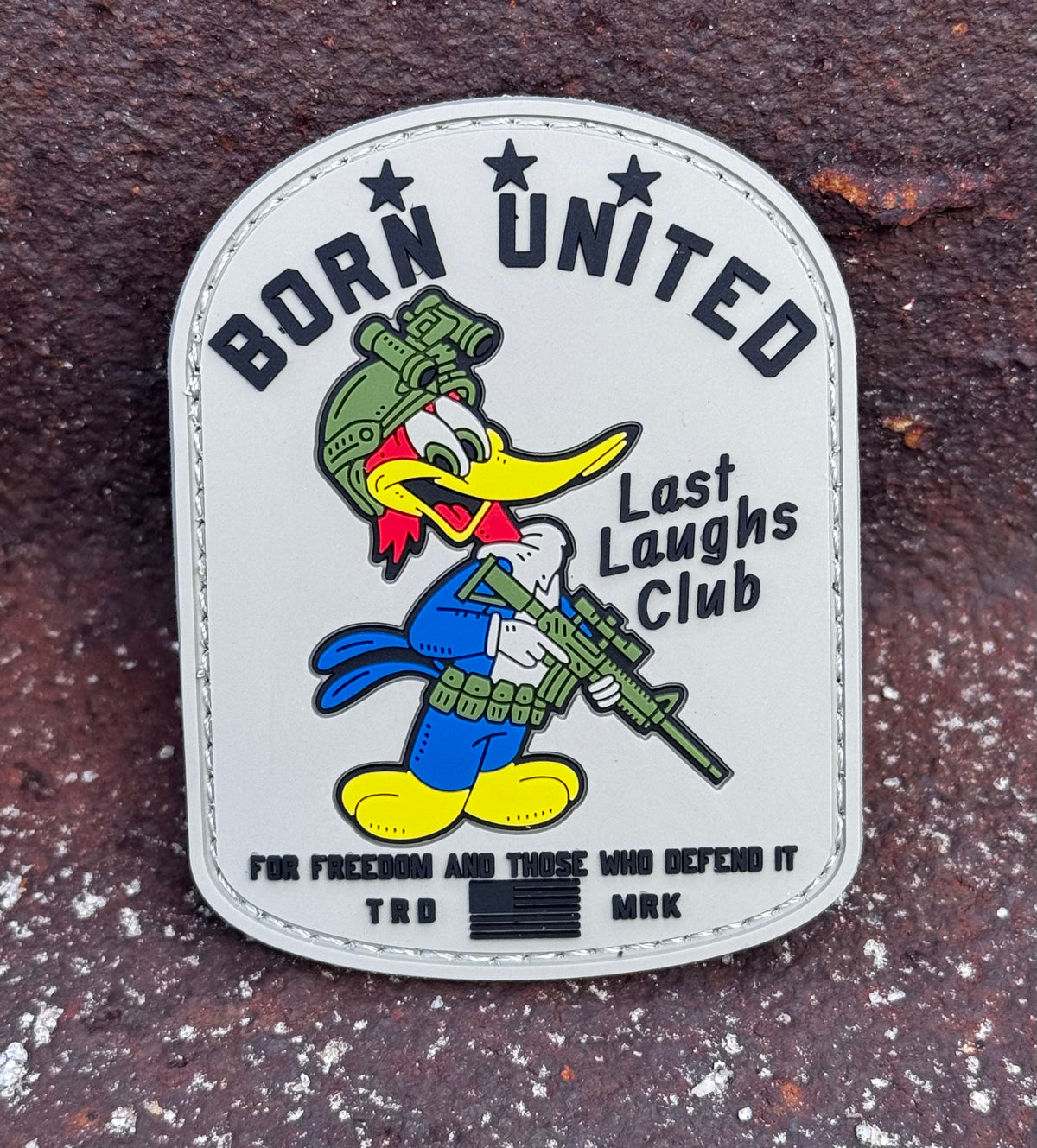 The Last Laughs Club PVC Patch by Born United Private Label shows a cartoon woodpecker in military gear with a rifle and features BORN UNITED, Last Laughs Club, and For freedom and those who defend it—a unique tactical accessory.