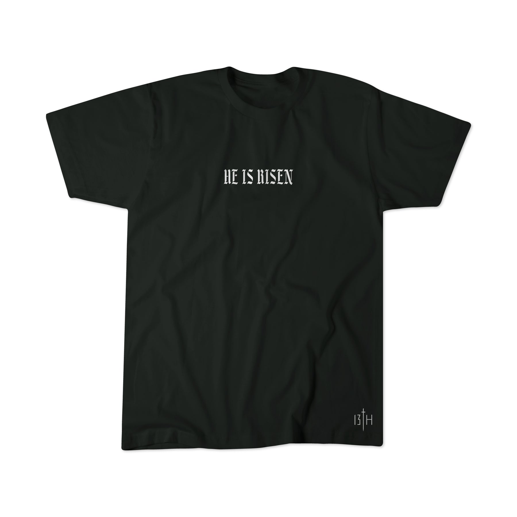 The He is Risen Premium Tee by 13th features bold, gothic "HE IS RISEN" text centered on a black shirt, with a small white 13th logo near the hem—a sleek, inspiring Christian resurrection tee.