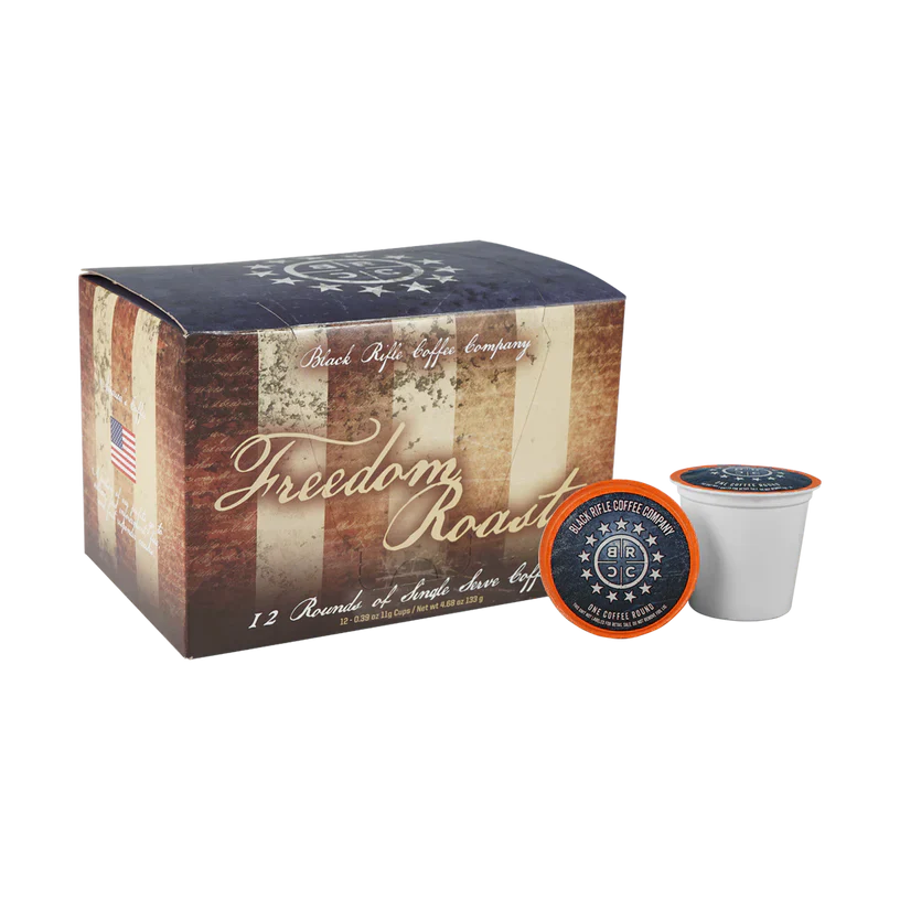 A box of Black Rifle Coffee Freedom Roast Rounds 12 Count features patriotic American flag graphics, with one single-serve pod in front highlighting milk chocolate and vanilla notes—celebrating America’s Coffee.