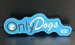 The Only Dogs PVC Patch by Tango Charlie Apparel is a blue and white pin featuring a dog silhouette in the letter O, OnlyDogs text, and Tango Charlie in the bottom right corner.