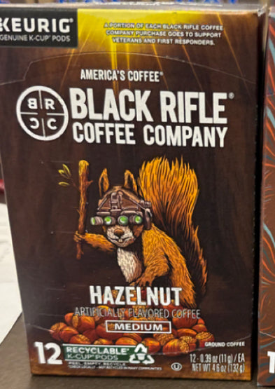 A box of Black Rifle Coffee Hazelnut Coffee Rounds, featuring an illustrated squirrel in night vision goggles with a rifle. Contains 12 medium roast, recyclable K-cup pods.