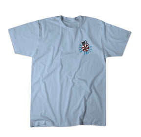 The Yukon Cornelius Tee by Born United Private Label is a light blue shirt with a small left chest graphic of a unicycle wheel and rider, symbolizing freedom, with "Mono City Uni" in curved blue text around the design.