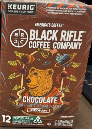 Black Rifle Coffee’s Chocolate 12ct Rounds offer chocolate-flavored medium roast in a box of 12 recyclable K-Cup pods with packaging featuring a bear, planets, and chocolate pieces.