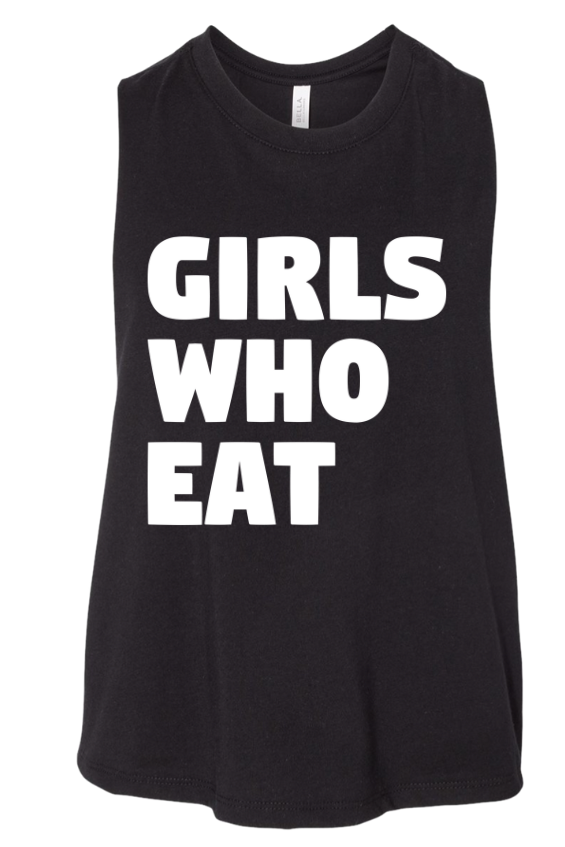 The Girls Who Eat - Crop Tank by Tango Charlie Apparel is a black sleeveless cropped tank featuring the phrase “GIRLS WHO EAT” printed in bold white uppercase letters on the front.