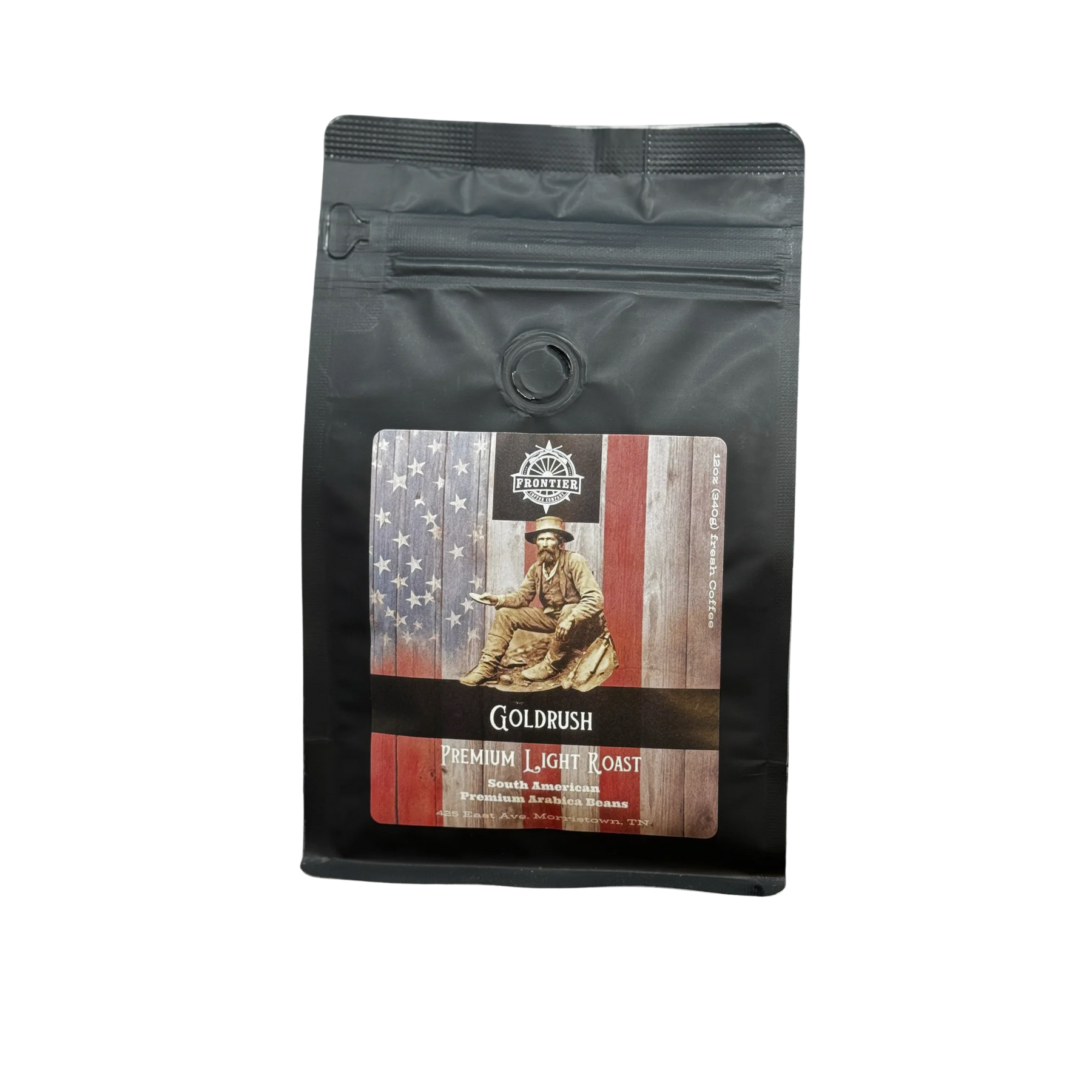 A black coffee bag labeled Frontier Coffee Gold Rush Light Roast - Whole Bean features a gold miner and American flag illustration, evoking the American Dream. This single origin Guatemalan coffee is sealed and stands upright on a white surface.