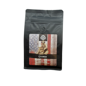A black coffee bag labeled Frontier Coffee Gold Rush Light Roast - Whole Bean features a gold miner and American flag illustration, evoking the American Dream. This single origin Guatemalan coffee is sealed and stands upright on a white surface.