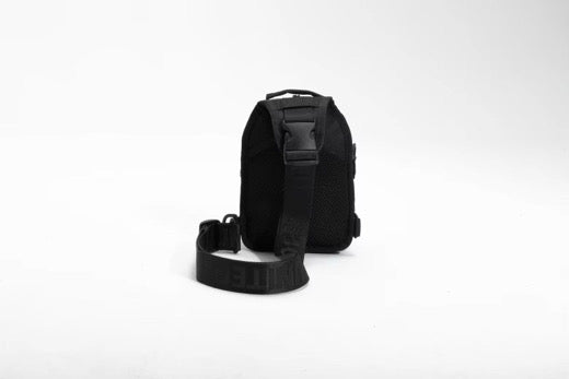 The Born United Private Label Black Phantom Tactical Sling-Pac - 4L is shown upright on a white background, featuring a compact rectangular shape and a wide adjustable strap extended in front for easy carrying.