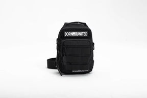 The Born United Private Label Black Phantom Tactical Sling-Pac - 4L is a compact black crossbody bag with "BORN UNITED" in white on both front pockets, displayed on a plain white background—ideal for carrying and organizing essentials.