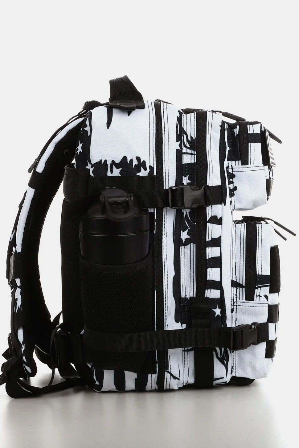 Side view of the American Stealth Special Edition Tac-Pac - 25L from Born United Private Label, showcasing a black and white pattern with a water bottle in a mesh pocket. The abstract design is inspired by stealth technology, set against a plain white background.