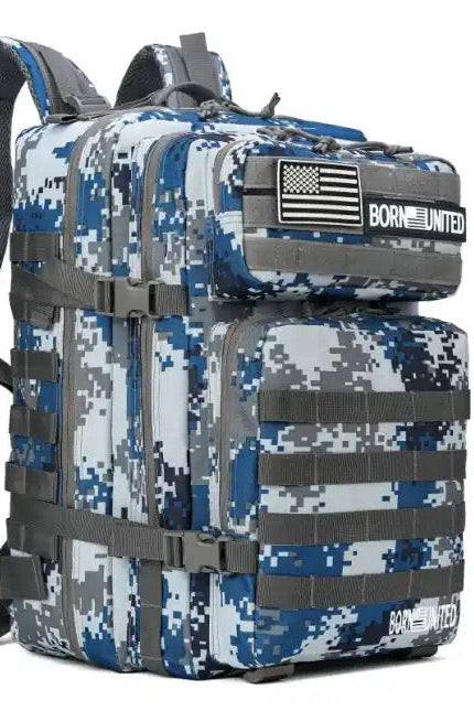 The Arctic Tac-Pac - 45L by Born United Private Label, in digital camo blue, white, and gray, offers multiple compartments and straps. A black and white Born United flag patch adorns the front. Padded shoulder straps guarantee comfort for all your adventures.