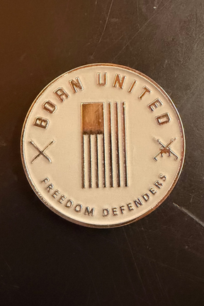 The Furbinator Challenge Coin by Born United Private Label displays "BORN UNITED" above, "FREEDOM DEFENDERS" below, a stylized U.S. flag in the center, and crossed swords—making a bold statement for any Furbinator supporter.