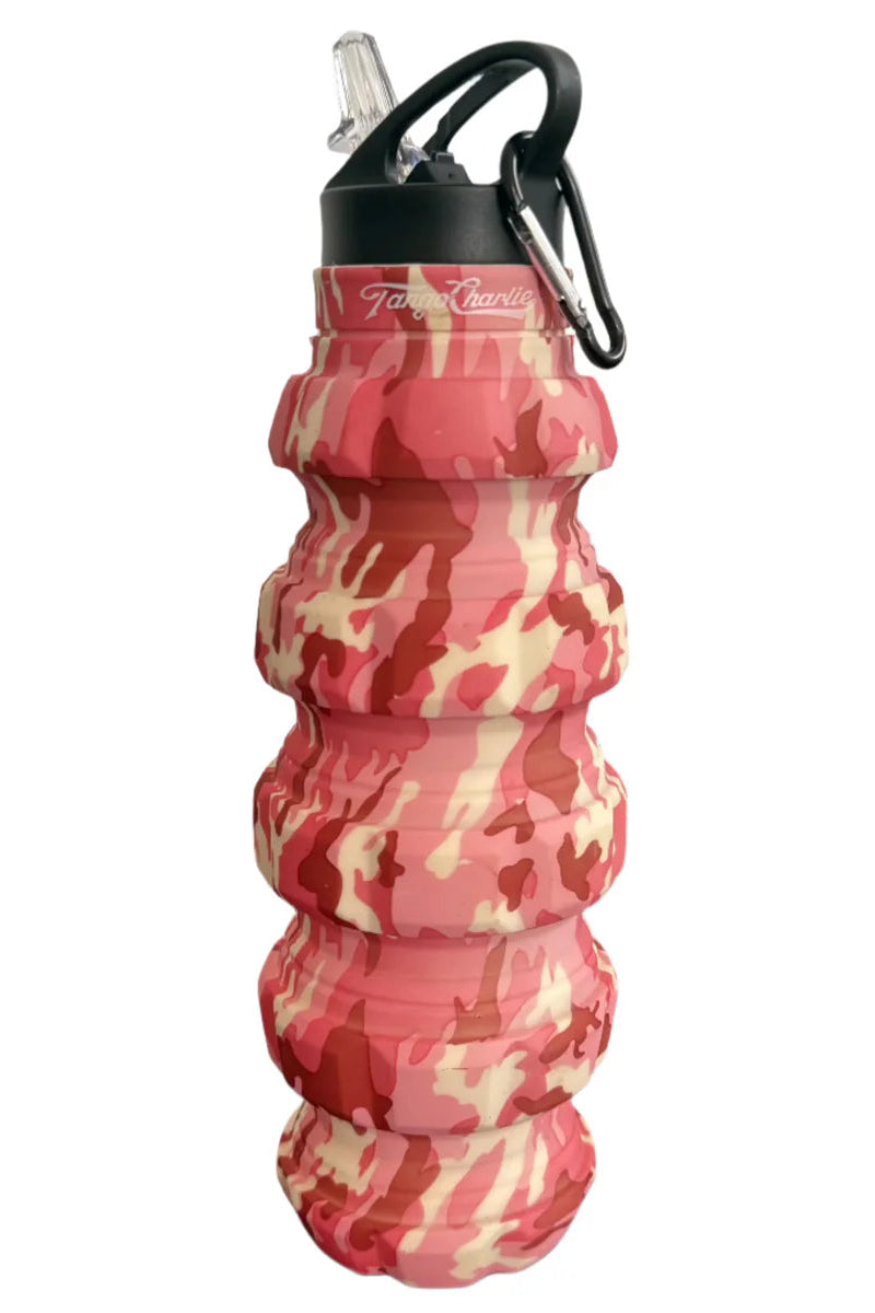 The Pink Camo Humble + Hydrated 20oz Water Bottle by Tango Charlie Apparel is a BPA-free, food-grade silicone bottle with a red, pink, and beige camo pattern, black flip-top lid and straw, plus a black carabiner for on-the-go hydration.