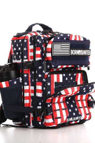 The Ultimate Patriot Special Edition Tac-Pac - 25L by Born United Private Label features an American flag-inspired design in red, white, and blue. It includes multiple compartments, adjustable straps, a front buckle, and a mesh side pocket for a water bottle. Its front displays Born United.