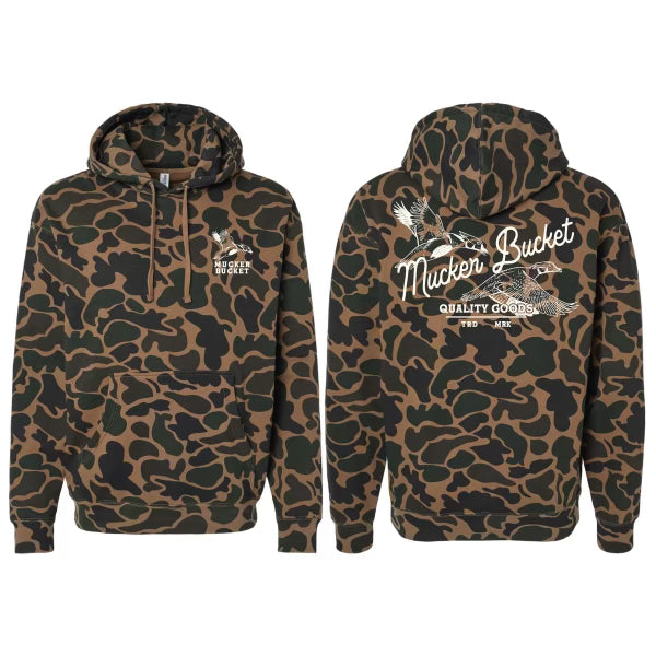 The MB Hood Youth - Wood Duck Camo Hoodie by Mucker Bucket features green and brown camo, "Mucker Bucket Quality Goods" and a bird graphic in white on the back, plus a smaller logo on the front left chest.