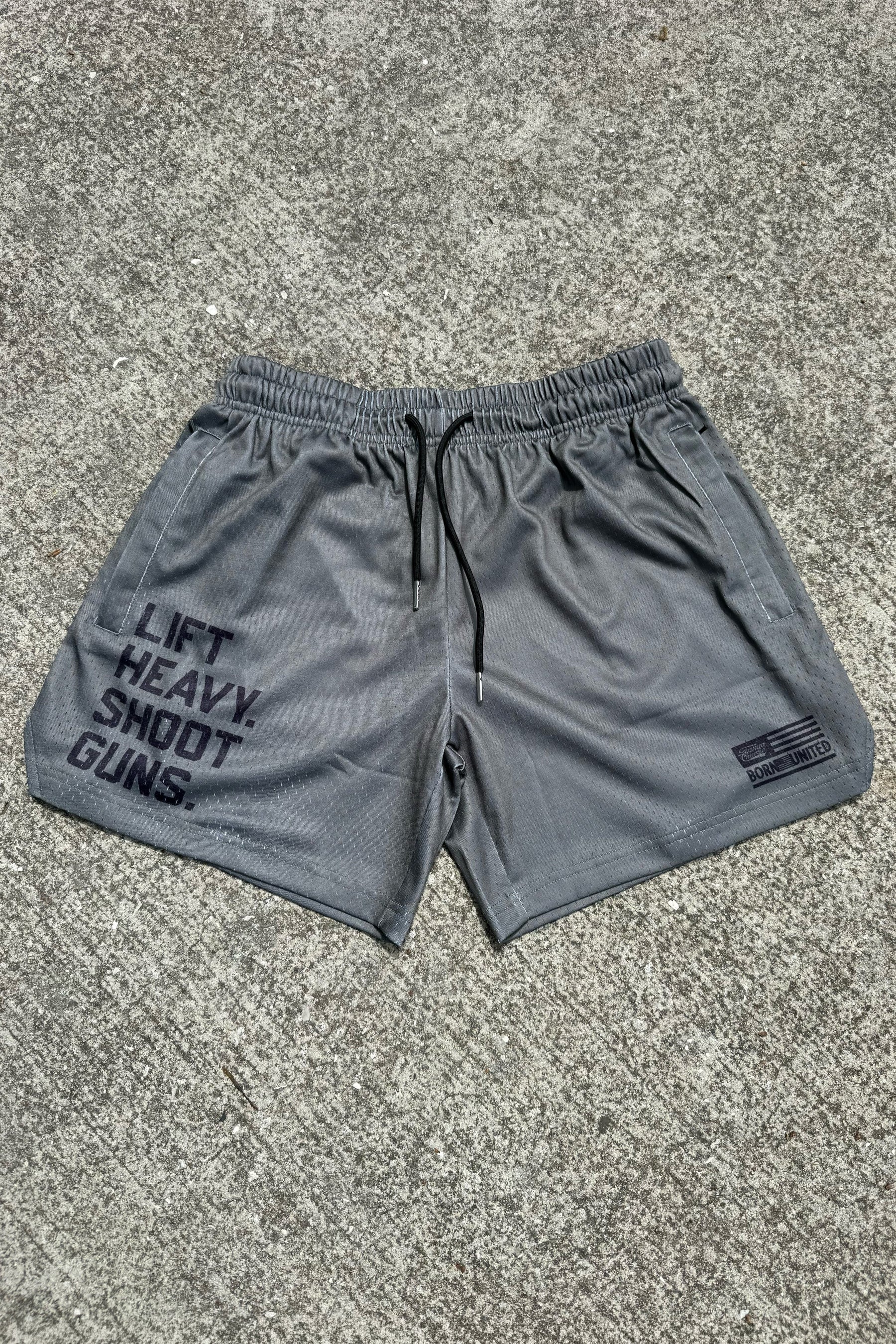 Men's Mesh Lifestyle Shorts | 5.5"- LHSG OD Green by Tango Charlie Apparel, featuring "LIFT HEAVY. SHOOT GUNS." in bold print on the left leg and a small SAVAGE UNITED logo on the right—perfect lifestyle athletic shorts.