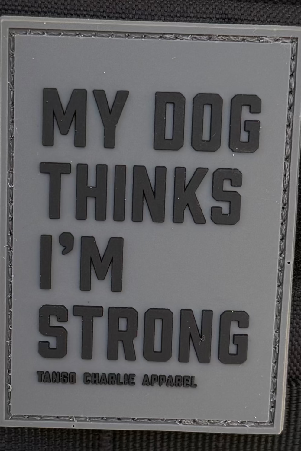 Patch with text 'My dog thinks I'm strong' on a black background
