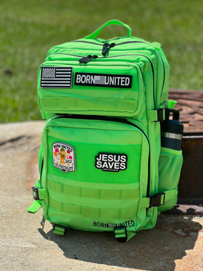 The Key Lime Tac-Pac - 45L by Born United Private Label, shown outdoors with “BORN UNITED,” “JESUS SAVES,” and flag patches, plus a round graphic patch and a water bottle in the side pocket, sits on concrete.