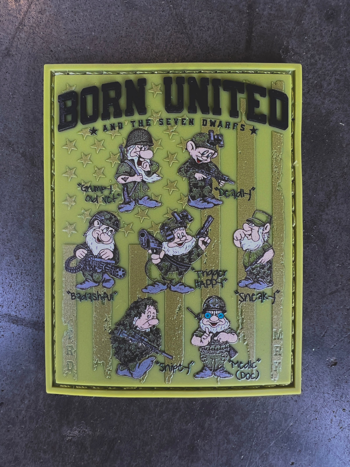 The Seven Soldiers Patch by Born United Private Label features cartoon dwarfs in tactical gear—Grumpy, Bashful, Sleepy, Doc, Happy, Sneezy, and Dopey—on a green striped background.