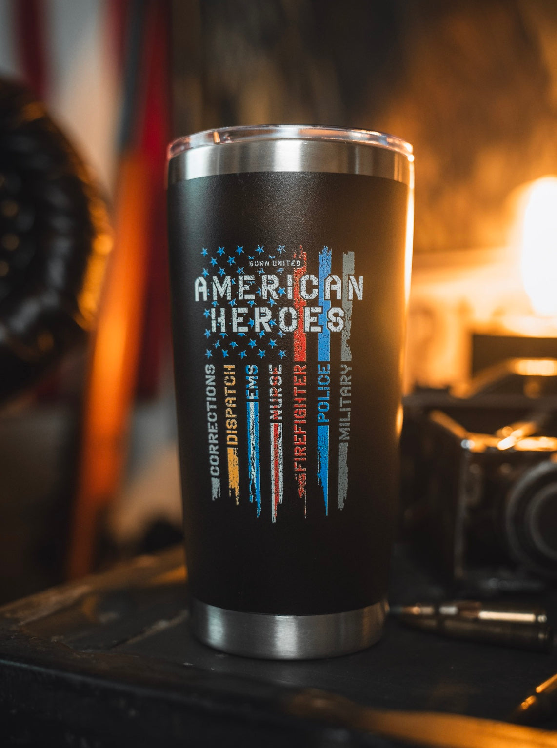 Celebrate everyday heroes with the Born United Private Label American Heroes Tumbler - 20oz, featuring colored stripes for corrections, dispatch, EMS, nurses, firefighters, police, and military. A bold black design that's perfect for showing your support.