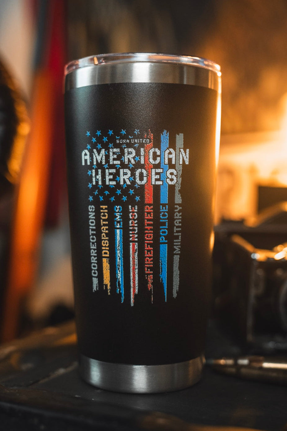 Celebrate everyday heroes with the Born United Private Label American Heroes Tumbler - 20oz, featuring colored stripes for corrections, dispatch, EMS, nurses, firefighters, police, and military. A bold black design that's perfect for showing your support.
