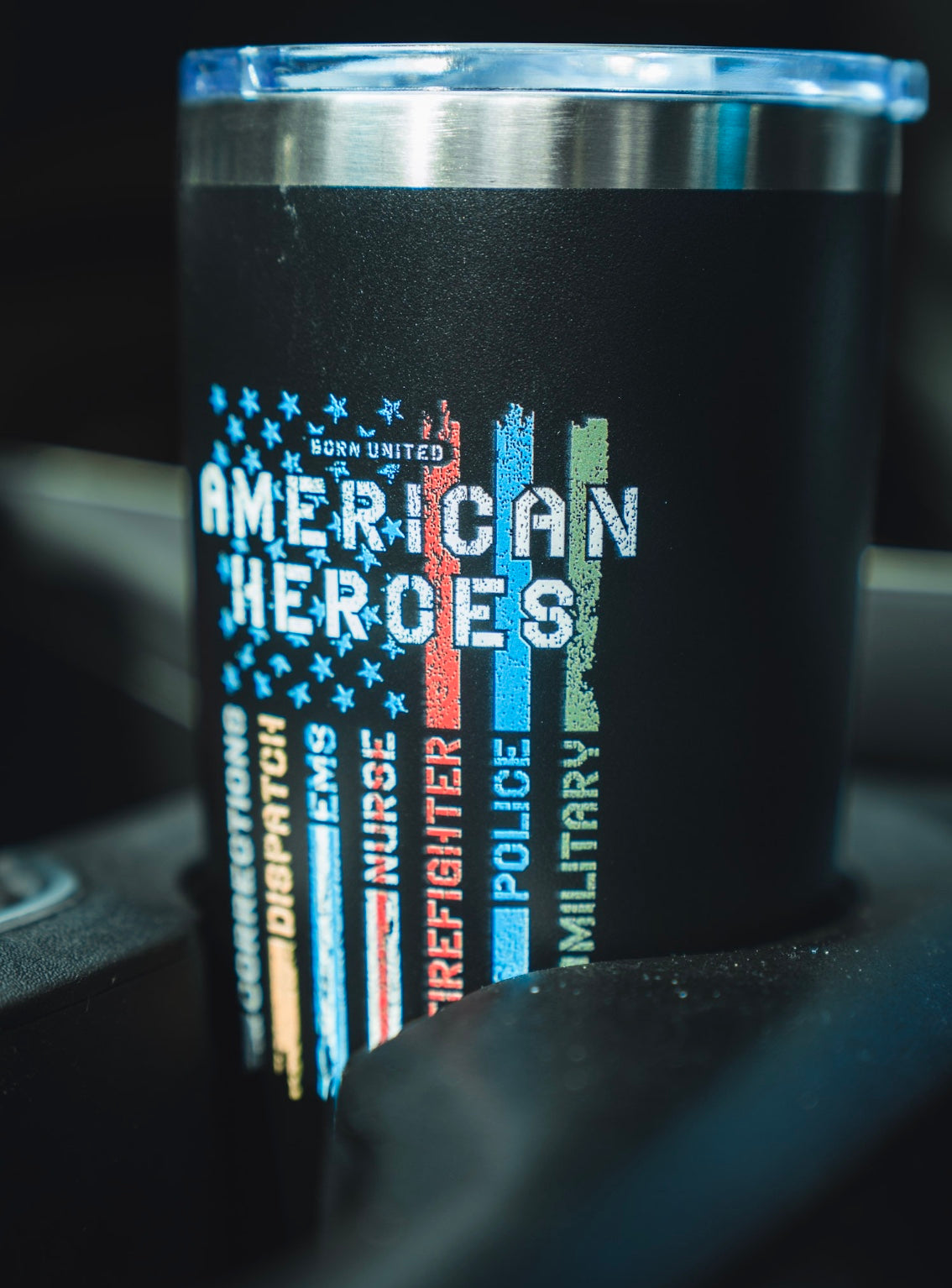 Display your pride with the Born United American Heroes Tumbler - 20oz, featuring a distressed flag with colored stripes honoring corrections, dispatch, EMS, nurses, firefighters, police, and military heroes.