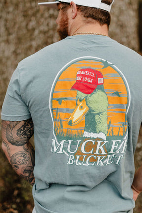 Man wearing a t-shirt with a graphic design of a horse and text, standing outdoors.
