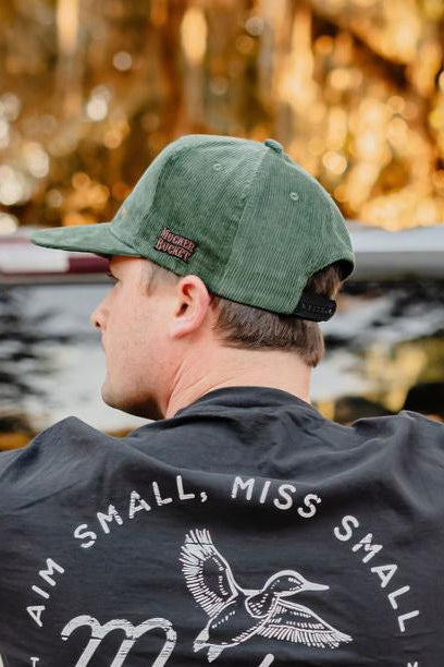 mucker bucket - duck green corduroy hat on model side