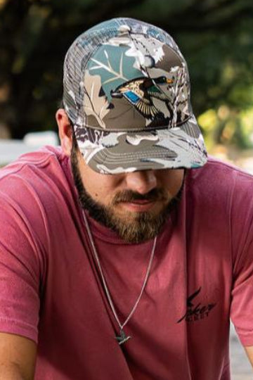 mucker bucket - mallard big woods camouflage trucker hat on model