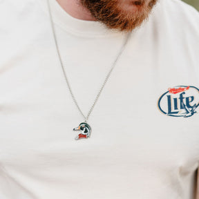 Close-up of a person with a reddish beard wearing a white shirt featuring a Life logo and the Mucker Bucket Wood Duck Necklace with stainless steel chain.