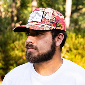 mucker bucket - chasin' tail fall camo trucker hat on model