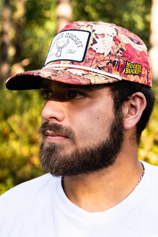 mucker bucket - chasin' tail fall camo trucker hat on model
