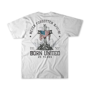 The We Remember: 25th Anniversary - White T-shirt by Born United Private Label features a striking graphic of a US flag on a cross amidst debris and a city skyline, with the text: NEVER FORGOTTEN 9/11/01, BORN UNITED 25 YEARS, Remember the Fallen, and Bring Justice Forward. This September 11 memorial remembrance tee honors those we lost and celebrates the enduring unity and resilience that emerged from tragedy.