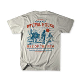 The Revival House Premium Tee from Born United Private Label features a light gray design with a bold graphic of a cowboy and camel in the desert, red sun, cacti, and text that reads: REVIVAL HOUSE, ONE OF THE FEW, MATTHEW 7:13-16. This Christian apparel piece captures the faith-driven spirit of a ranch lifestyle with its inspirational message and standout style.