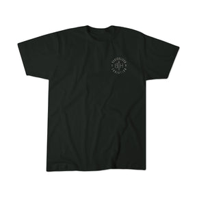 The Radicalized Christian Premium Tee by 13th is a black short-sleeve t-shirt featuring a small white circular logo with “13TH” text on the left chest, inspired by Matthew 16:25—“For whoever wants to save his life will lose it.”.