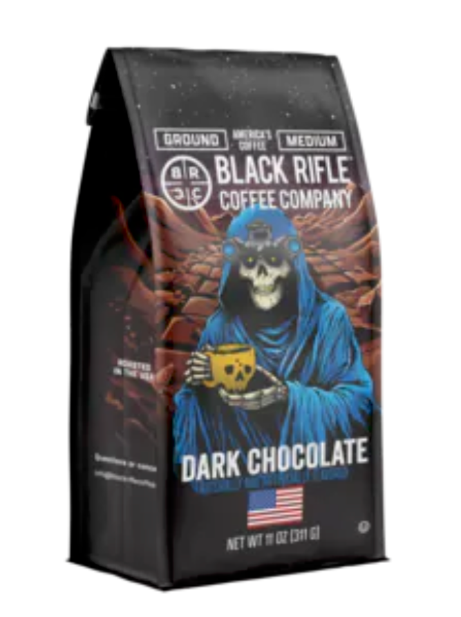 Black Rifle Coffee’s Dark Chocolate 12oz Ground features a skeleton in a blue robe with a yellow mug, set against a starry sky and American flag on the packaging.