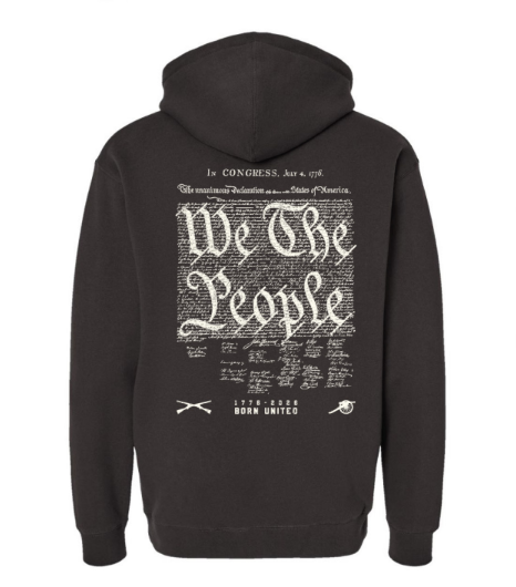 Back of a black We The People Hoodie featuring a white graphic of the Declaration of Independence, the words We The People, and small illustrations of crossed muskets and a cannon.