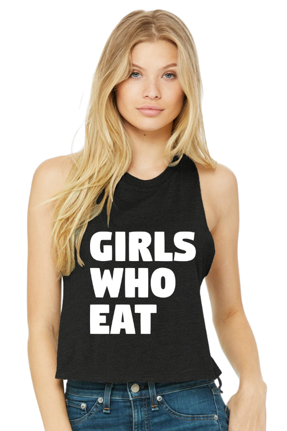 A woman with long blonde hair wears the Girls Who Eat - Crop Tank by Tango Charlie Apparel, a black racerback style featuring bold white text across the front.