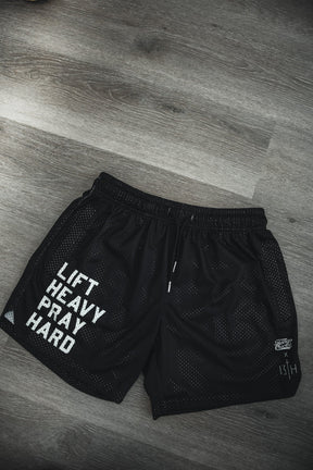 Tango Charlie Apparel's Men's Mesh Lifestyle Shorts | 5.5" in black feature "LIFT HEAVY PRAY HARD" text and a 13TH logo—perfect gym shorts for workouts or everyday wear.