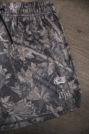 Men's Mesh Lifestyle Shorts | 5.5" - Lift Heavy Pray Hard Deadwood by Tango Charlie Apparel, shown in gray camo with a black drawstring, Rango Charlie logo, and two white symbols near the hem—great for everyday wear.